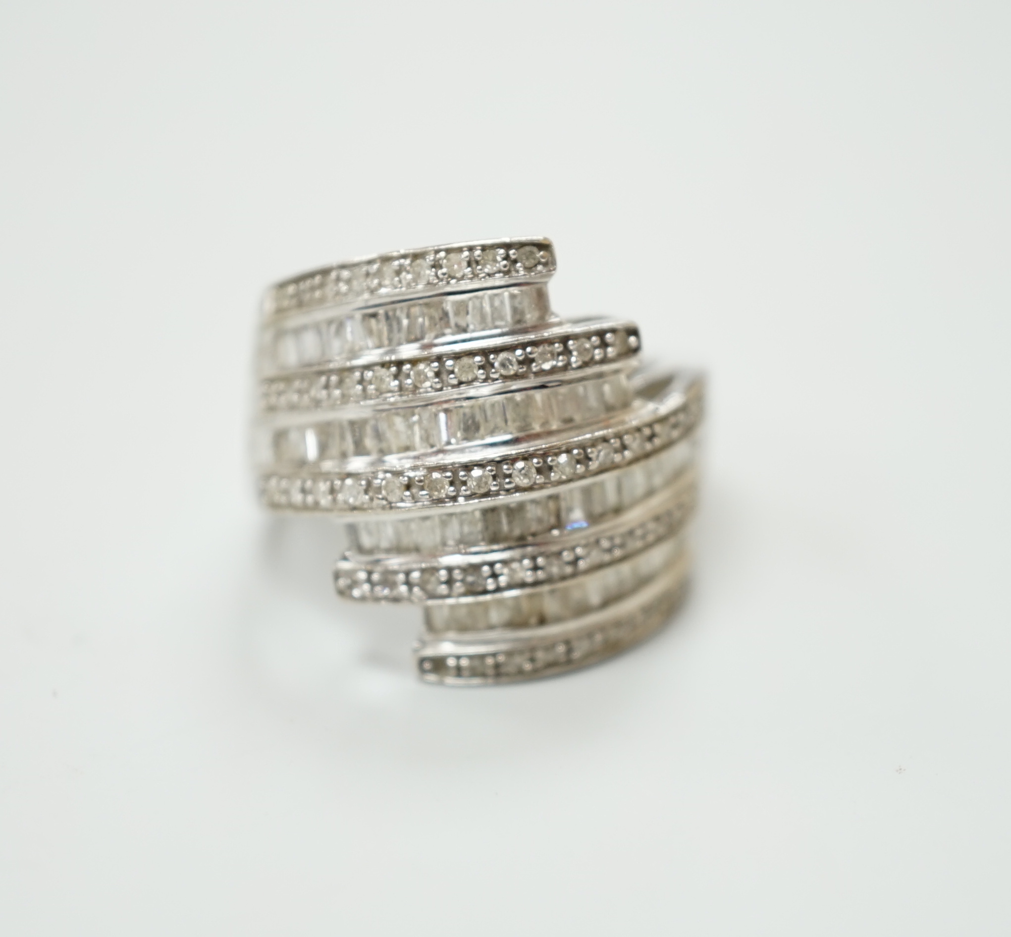 A 9ct white gold and dress ring designed with nine bands of brilliant and baguette cut stones, size N